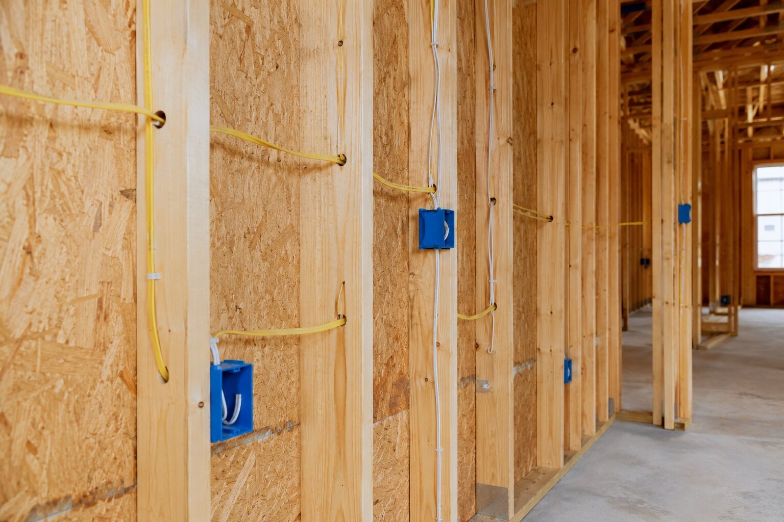 Electrical wiring installed through wall studs during new home construction, before drywall.